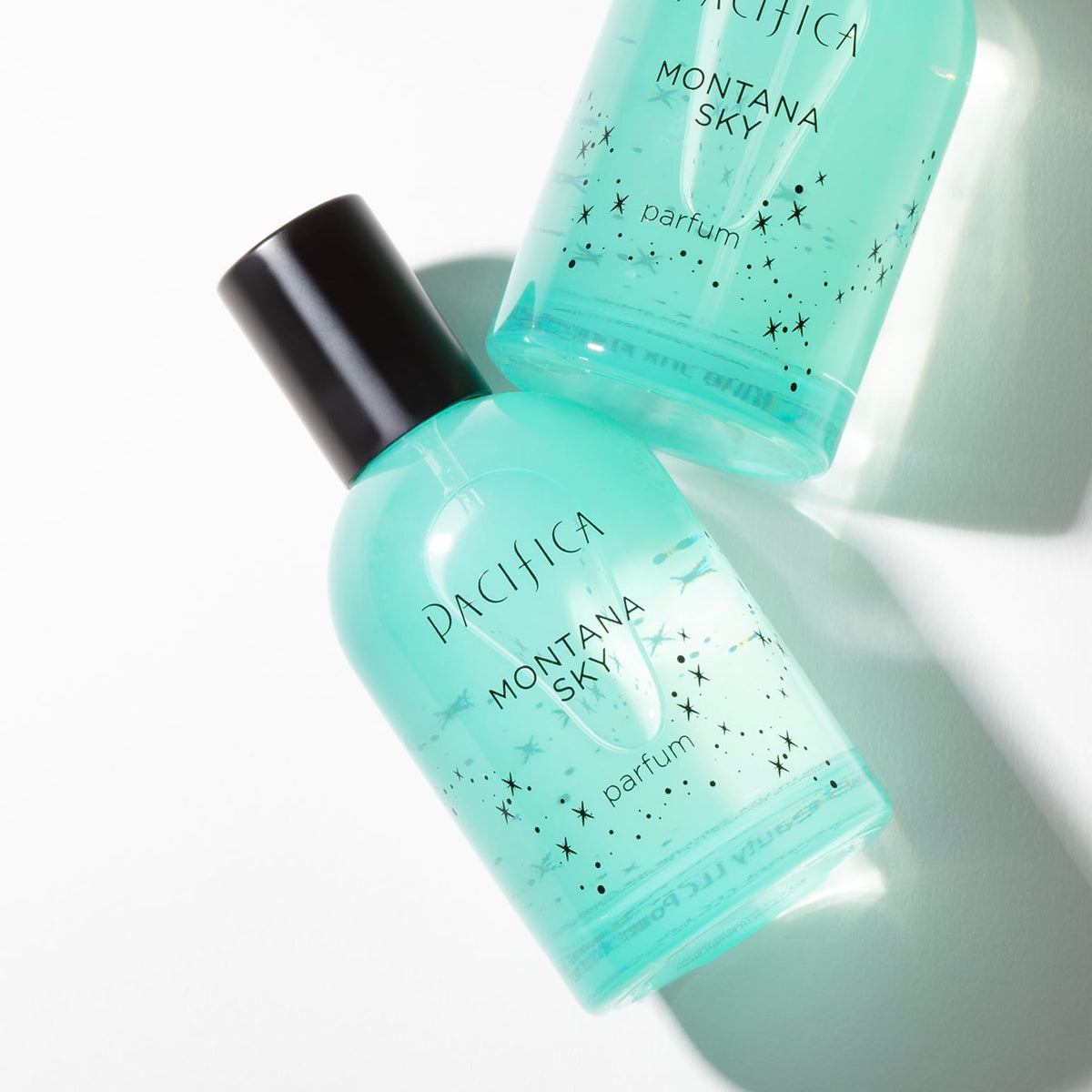 Pacifica Montana Sky Spray Perfume bottle against greenery