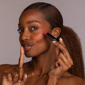 Perricone MD No Makeup Blush Balm on a vanity with other makeup products
