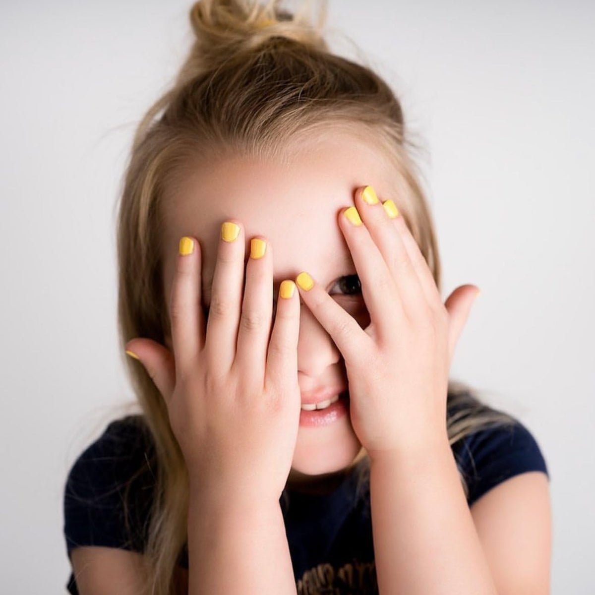 Piggy Paint Sunshine Yellow nail polish in a bright setting