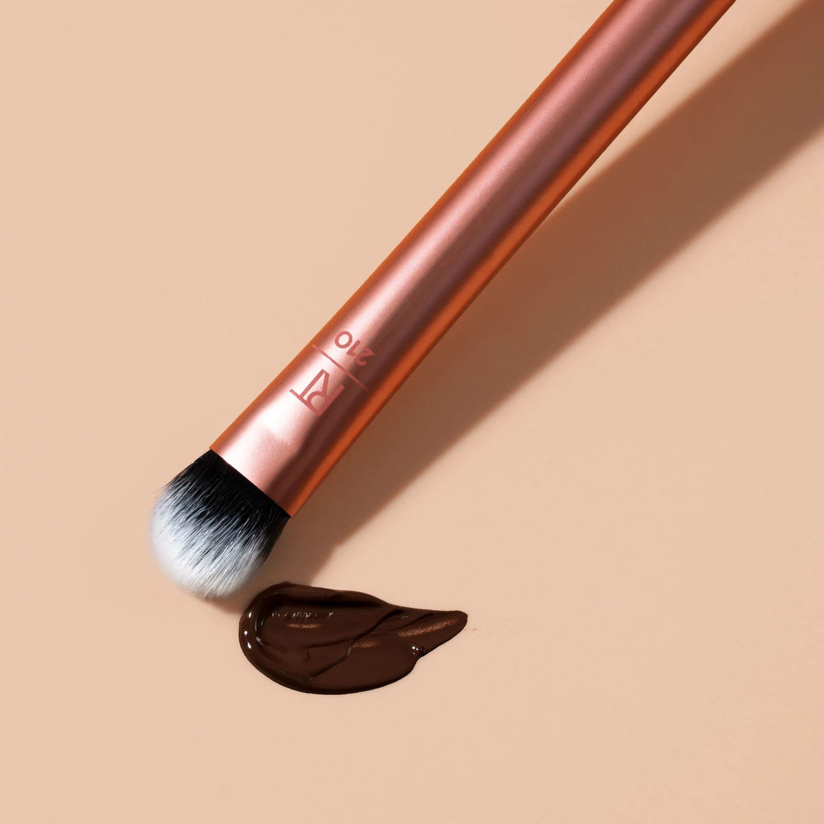 Real Techniques Expert Concealer Brush in hand demonstrating use