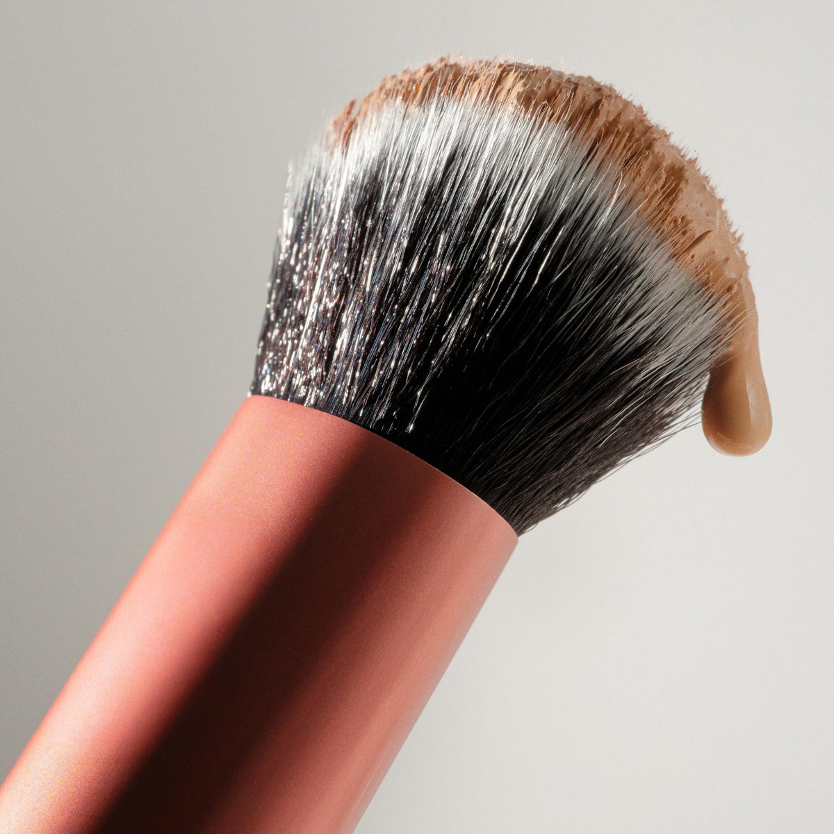 Real Techniques Expert Face Brush with background of makeup products