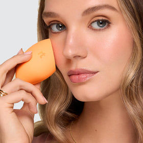 Real Techniques Miracle Complexion Sponge Duo on a vanity with makeup products