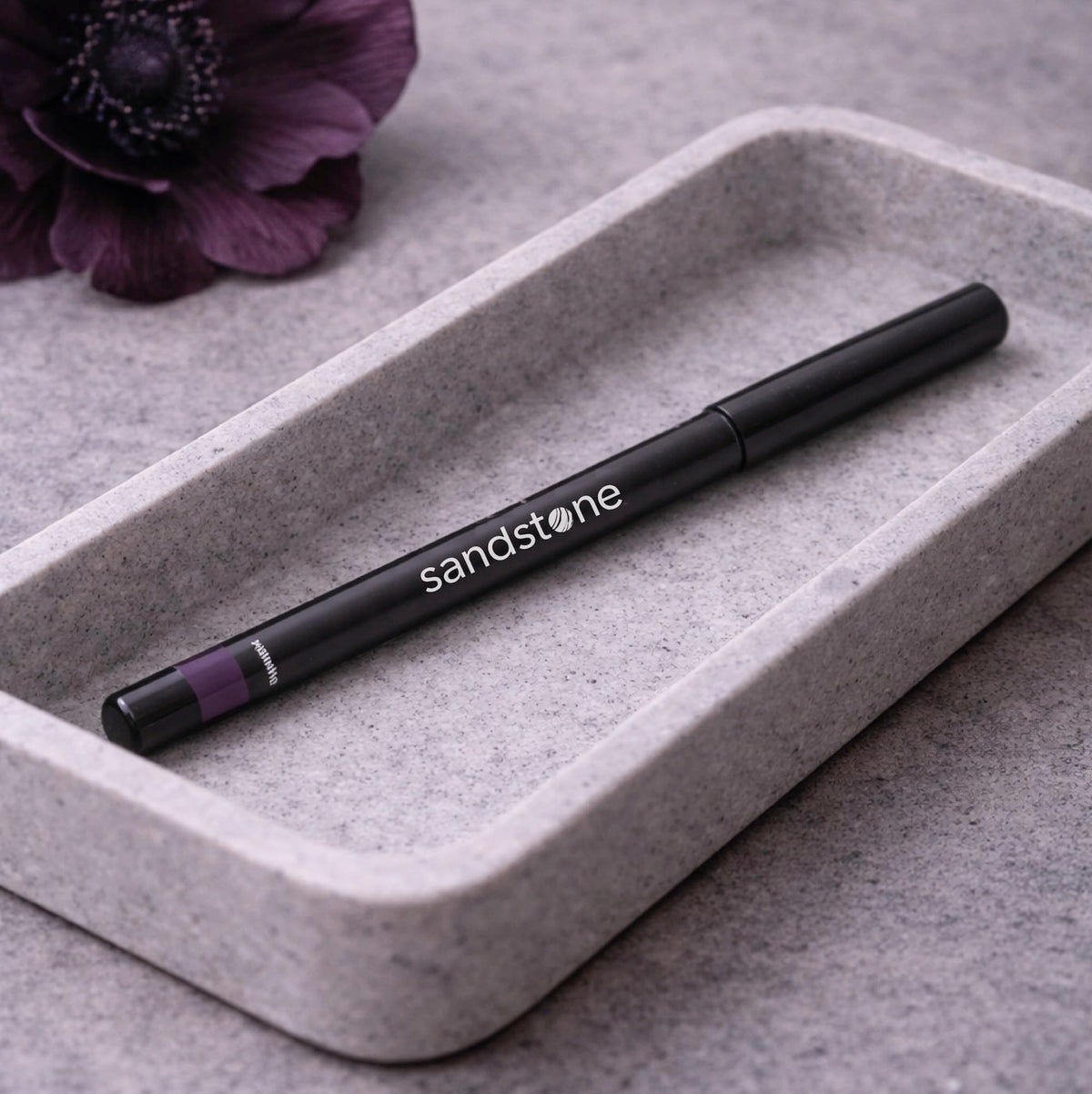 Sandstone Scandinavia Eyeliner Pencil Aubergine next to other makeup products