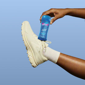 Secret Outlast Antiperspirant Deodorant in hand with lavender background