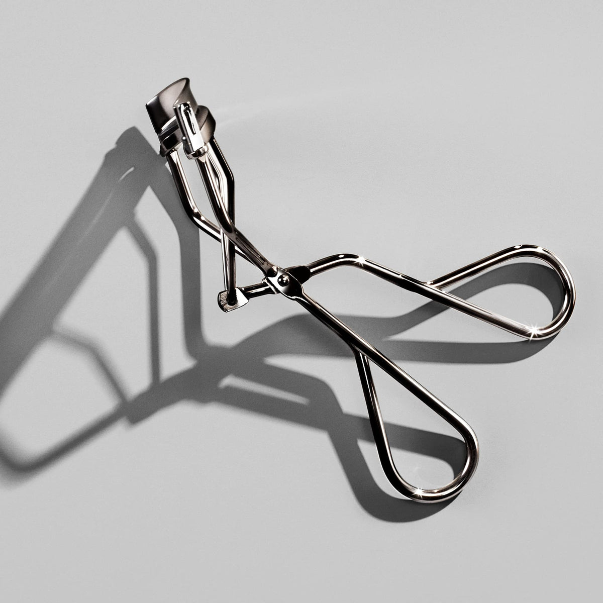 Shiseido Eyelash Curler on a vanity with makeup products