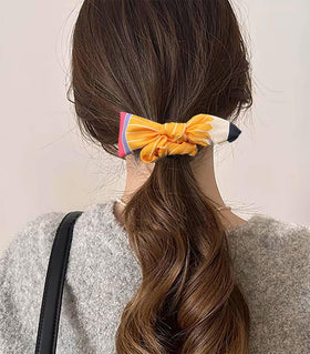 SKIRIFLA Pencil Bow Headband displayed with school supplies
