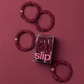 SLIP maroon silk skinny scrunchies set of 4 on a table
