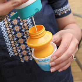 Solar Buddies applicator filled with sunscreen on a beach
