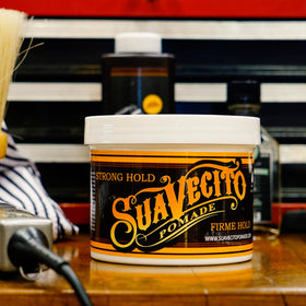 Suavecito Pomade displayed with grooming tools