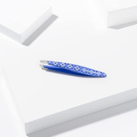 Tweezerman Mini Slant Tweezer held in hand for demonstration