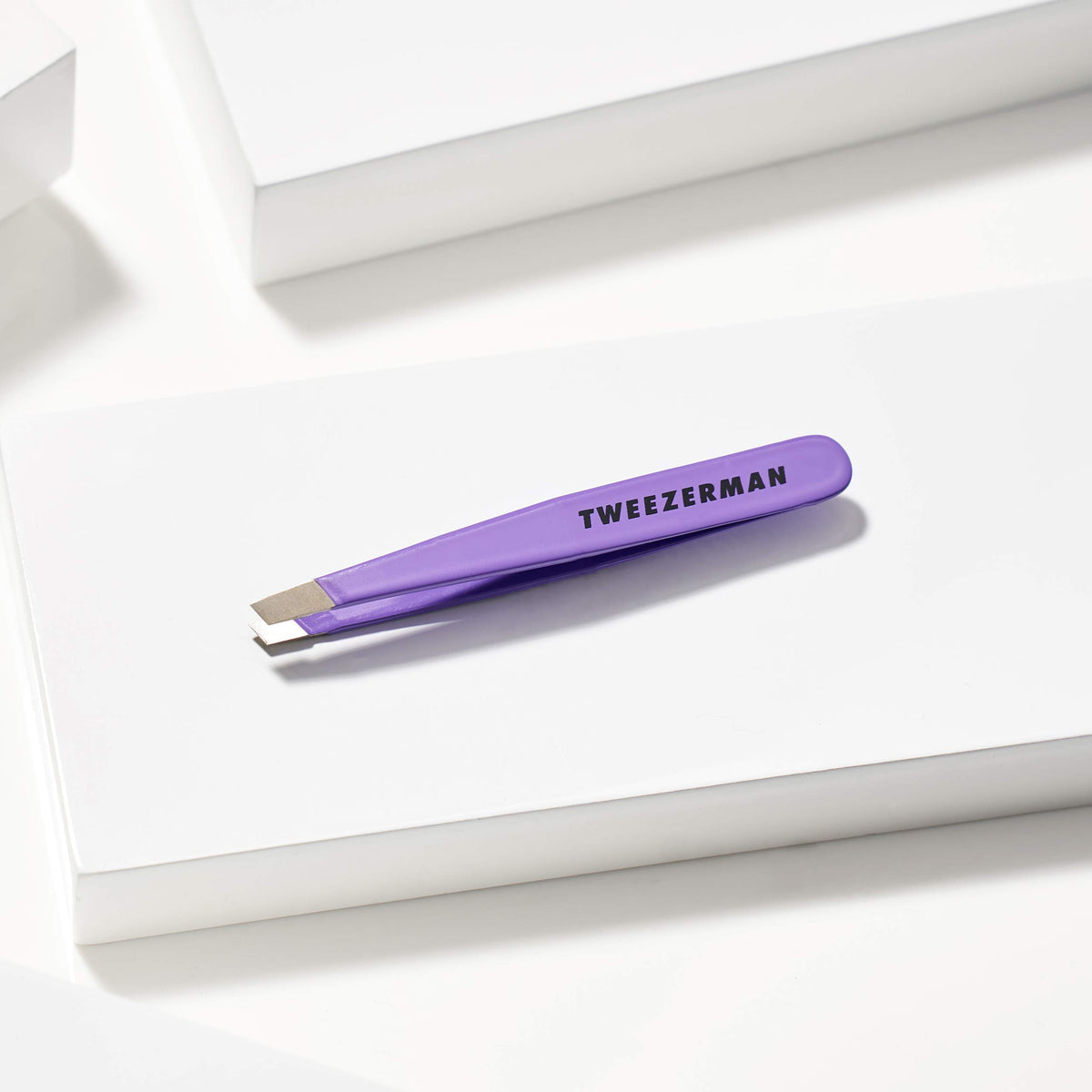 Tweezerman Mini Slant Tweezer in hand for usage