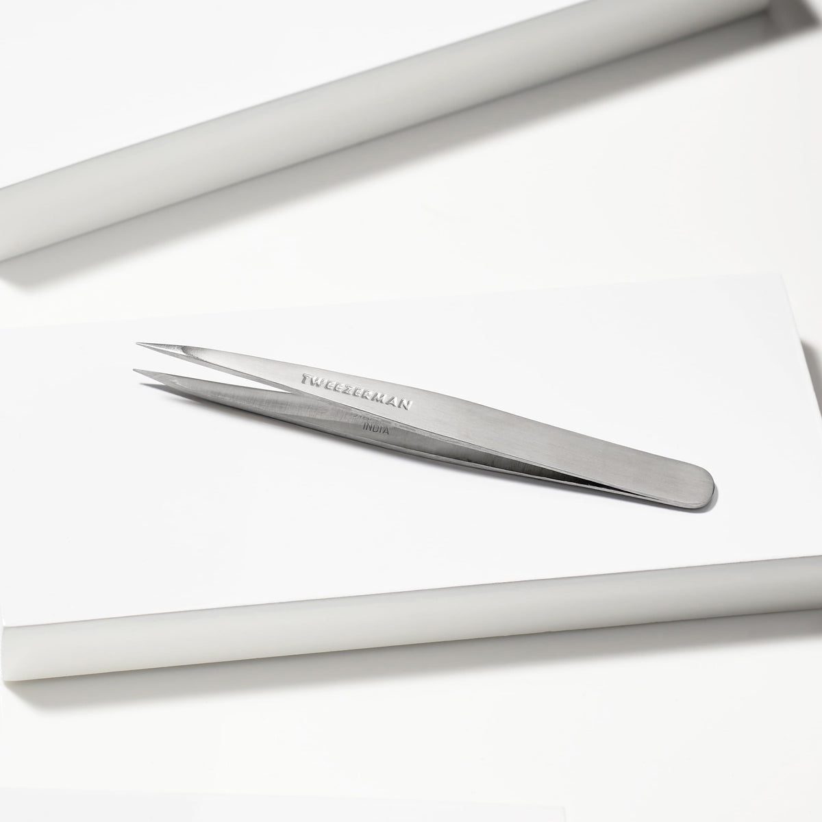 Tweezerman Steel Point Tweezer in hand for demonstration