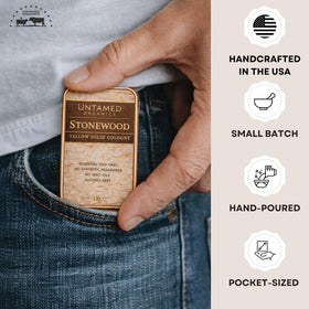 Untamed Organics Stonewood Tallow Solid Cologne tin next to grooming accessories