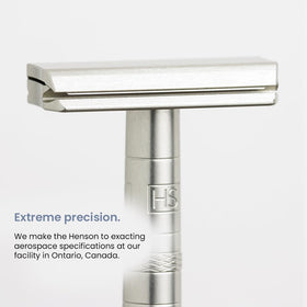 User holding Henson Shaving Razor in a bathroom setting
