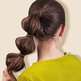 Woman using IKOCO hair ties for a ponytail