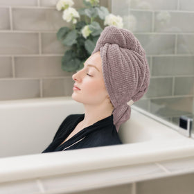 Woman using ROLSHOL Microfiber Hair Towel Wrap while applying makeup